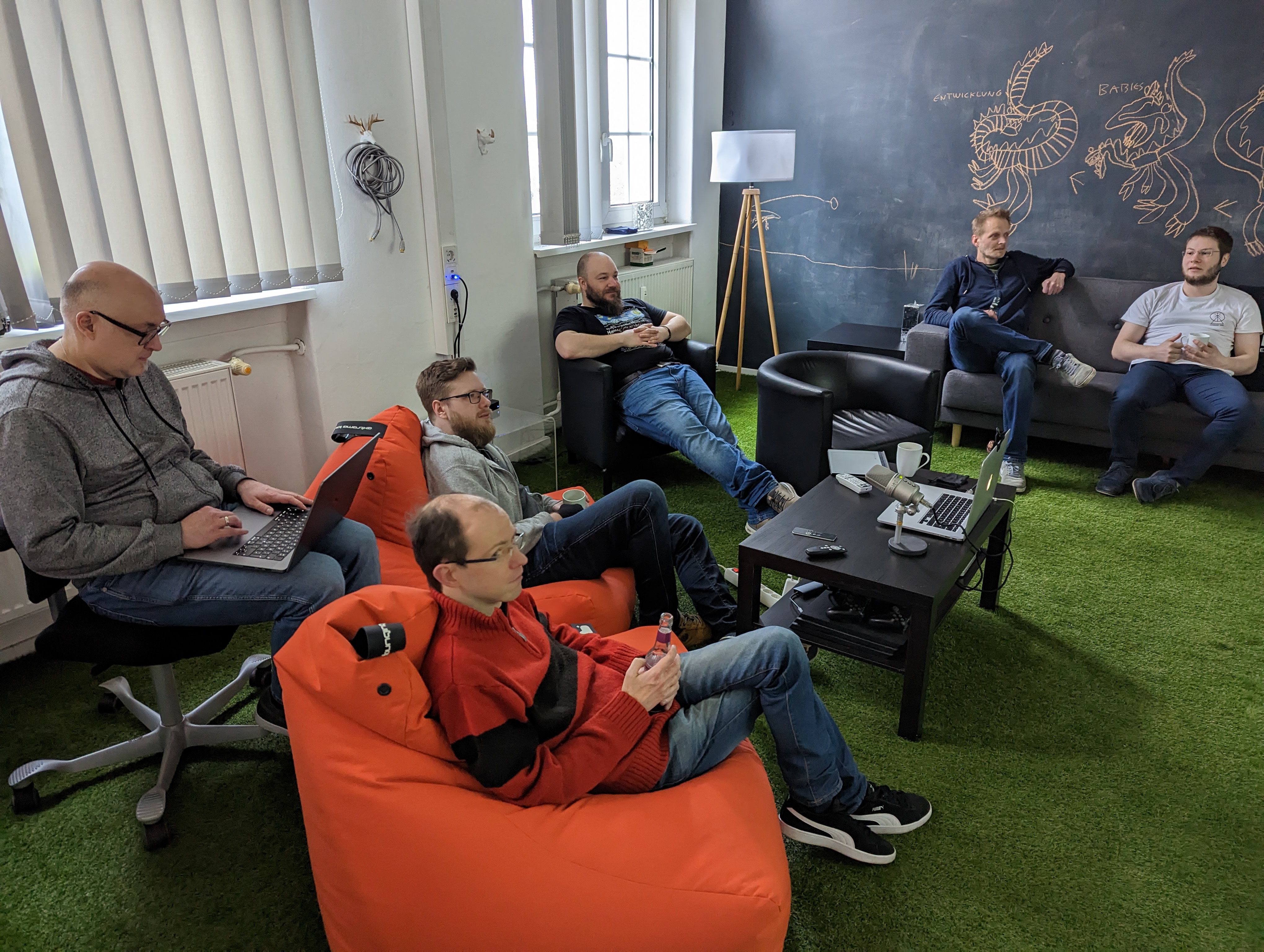 Das erdfisch Team sitzt gemütlich und entspannt im Besprechungsraum in Sesseln und Sitzsäcken